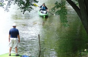 Man paddling in a Canoe toward dock fluid fun kayak and canoe